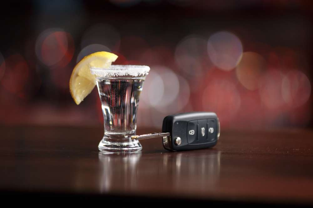 A Shot Of Tequila Next To Car Keys On A Table